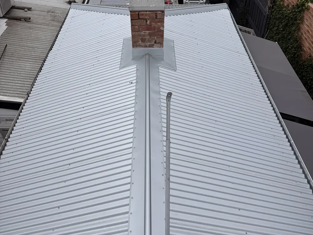 The same roof re-sheeted in new light Colorbond with reformed chimney flashing