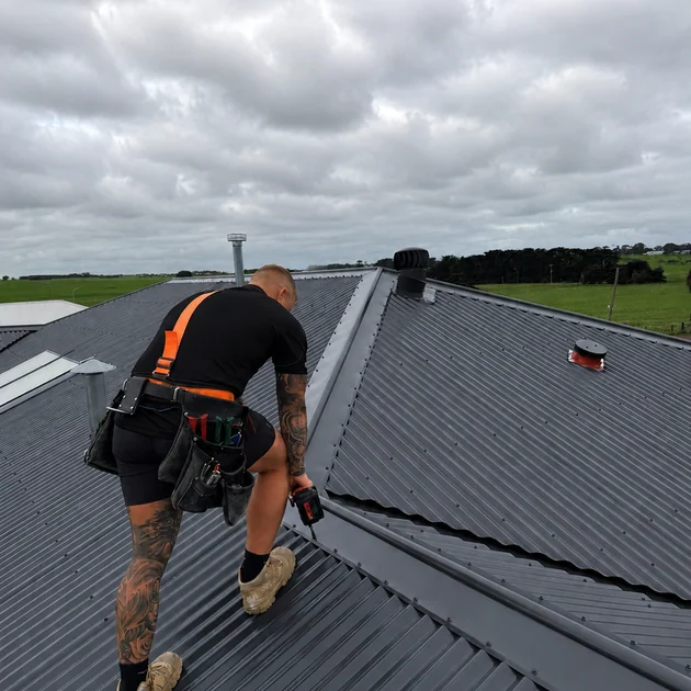 Stormside roof plumber fixing down new metal sheets on a Melbourne roof
