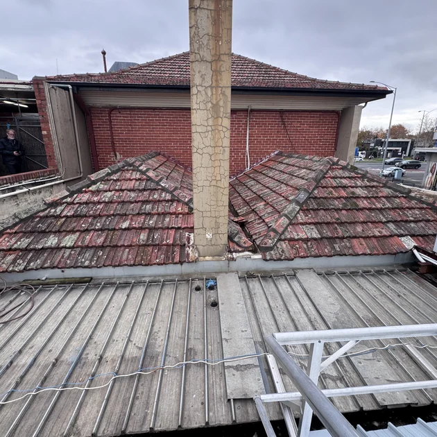 Worn tile roof in Melbourne with a corroded valley and cracked tiles